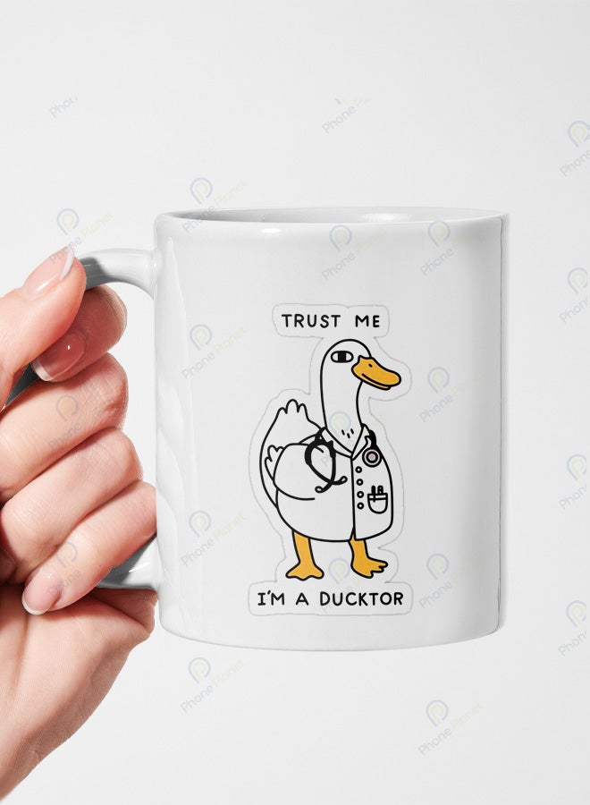 A ceramic mug printed with the phrase trust me I'm a doctor and featuring a comfortable handle