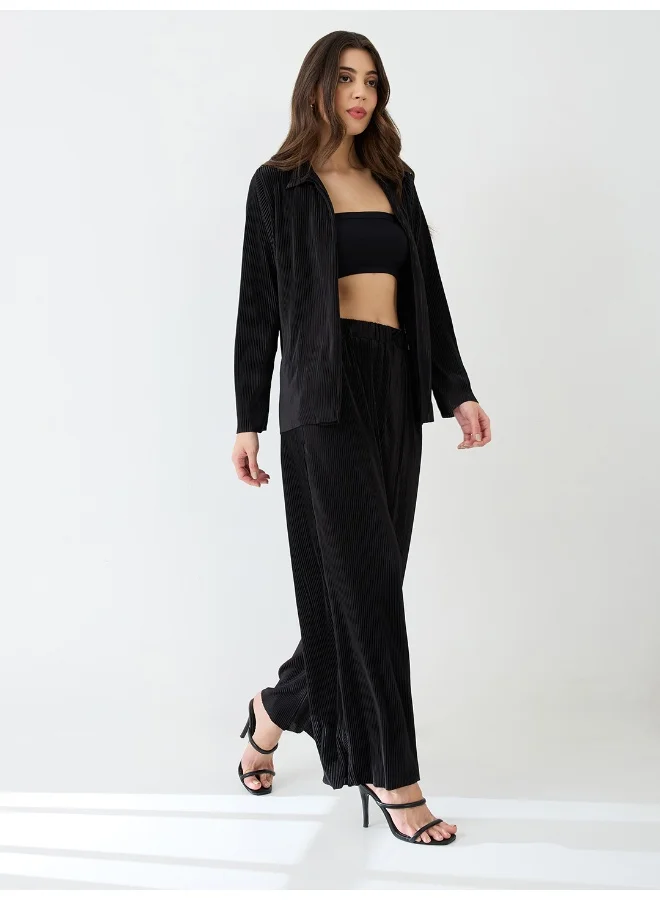 جلو باص طقم نسائي بلوزة بطيات أكورديون وبنطلون واسع الأرجل مطاطي