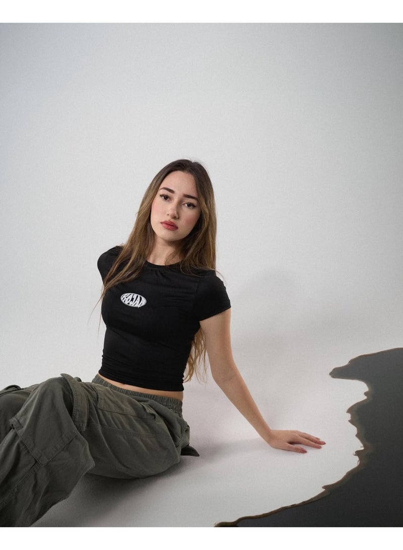 تيشيرت حريمي قصير باللون الأسود، خامة مرنة ومُحكمة على الجسم، بتصميم بسيط أمامي مناسب للخروج اليومي بإطلالة كاجوال وعصرية. - Image 1