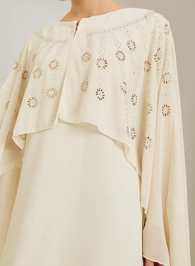 ستايلي قفطان طويل كريمي بأكمام كيب مزينة