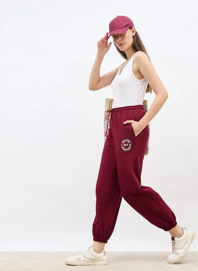 Styli Styli Burgundy Tapered Joggers with Graphic Print