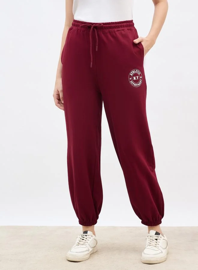Styli Styli Burgundy Tapered Joggers with Graphic Print