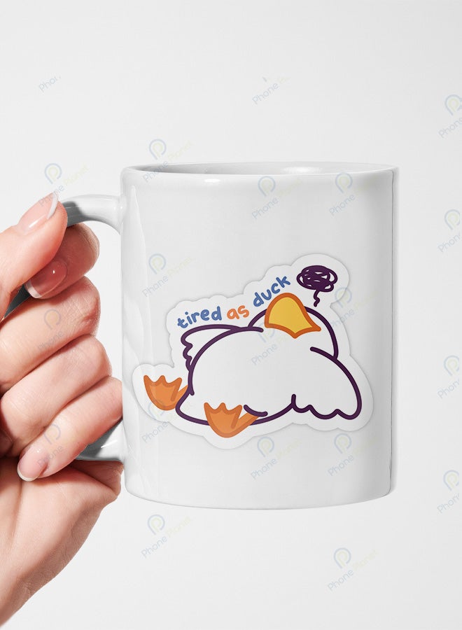 A ceramic mug printed with the phrase Tired Duck and featuring a comfortable handle