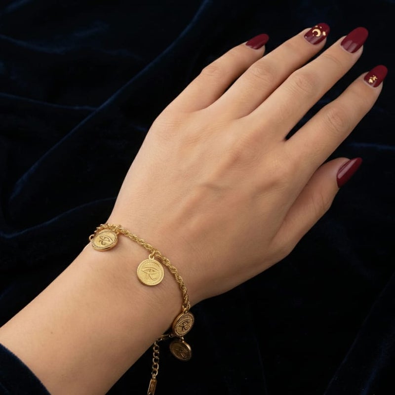 An elegant gold bracelet made of rust-resistant stainless steel, with a braided chain from which five coins with the Eye of Horus dangle, a design that highlights your look, with an adjustable clasp to suit you. - Image 4