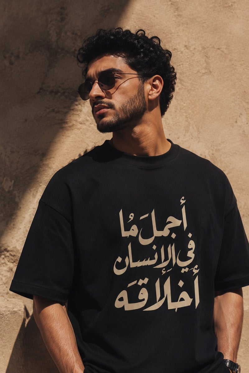تي شيرت رجالي أسود بقصة واسعة وطبعة كتابة عربية تصميم عصري بأكمام قصيرة وياقة دائرية - Image 1