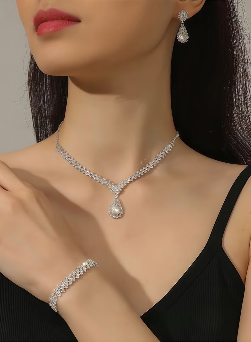 طقم نسائي مكون من 4 قطع من أحجار الراين، يتضمن قلادة وأقراط وسوار، مع قلادة على شكل قطرة، وسلسلة على شكل حرف V، وأقراط متدلية، وإكسسوارات أنيقة لفساتين الزفاف والسهرات، باللون الفضي البسيط والمتعدد الاستخدامات. - Image 1