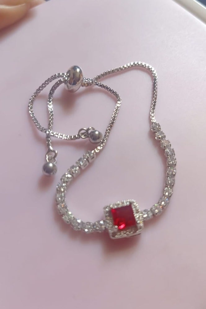 Luxuria Tennis bracelet with a red stone in the middle - Image 1
