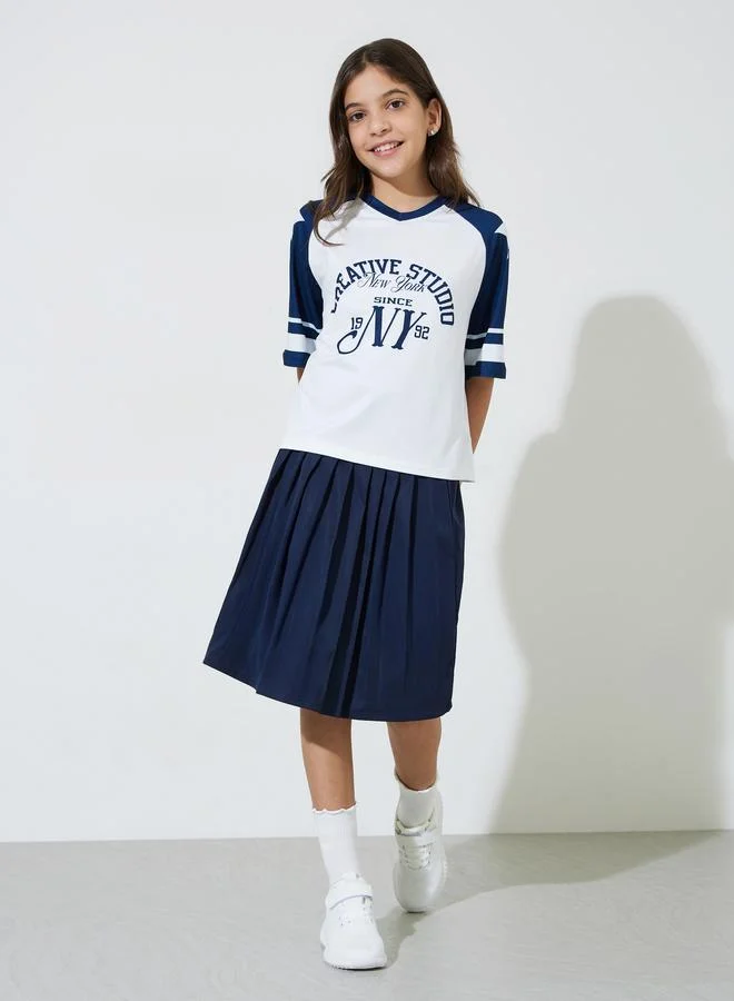 Styli Teen Girls Graphic Print Oversized T-Shirt and Pleated knee Length Skirt Set