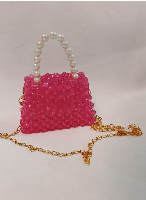 A hand-made bag made o crystal fuchsia in color with an imported pearl handle and a long one meter long gold-plated metal strap. The bag is 13 cm wide and 9 cm long. It is very suitable for children for daily use and evening parties