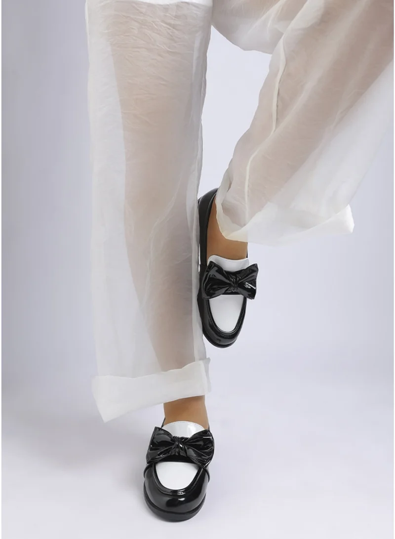 لندن راج حذاء لوفر كلاسيكي نسائي من لندن راج بتصميم سميك مزين بفيونكة باللونين الأسود والأبيض.