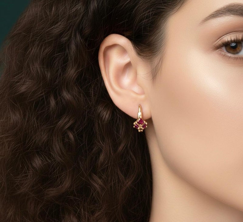 Gold earrings adorned with square ruby-red stones, featuring a striking geometric design reminiscent of a precious "gift." A piece that combines delicacy with bold color for a captivating look. - Image 3