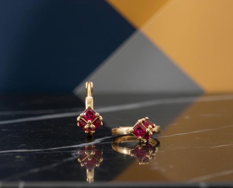 Gold earrings adorned with square ruby-red stones, featuring a striking geometric design reminiscent of a precious "gift." A piece that combines delicacy with bold color for a captivating look. - Image 5