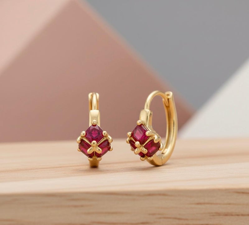 Gold earrings adorned with square ruby-red stones, featuring a striking geometric design reminiscent of a precious "gift." A piece that combines delicacy with bold color for a captivating look. - Image 4