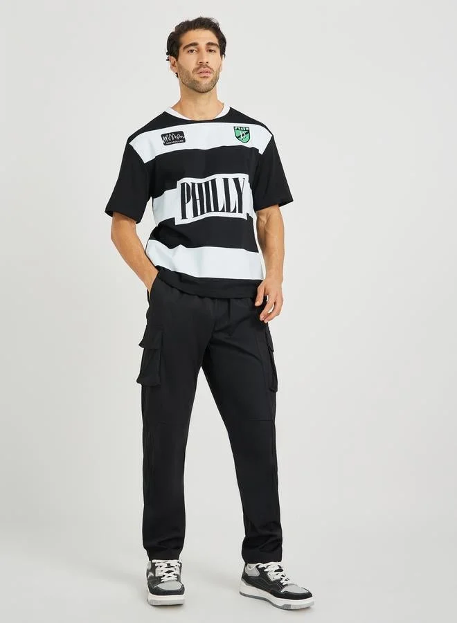 ستايلي تيشيرت ستايلي بطبعة نصية بياقة دائرية وقصة بوكسي فيت