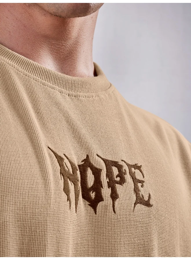مانياك تيشيرت قطن مانياك رجالي بتطريز "هوب" ورقبة دائرية وأكمام 3/4 بلون بسكويت