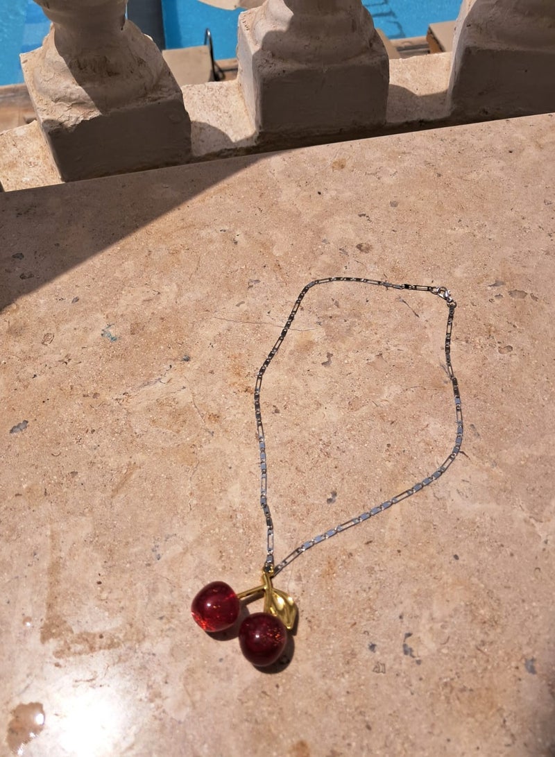 Gerenic Stainless Steel Chain in Cherry ShapeA delicate chain made of durable stainless steel in a sleek, solid color, adorned with a modern and attractive cherry-shaped pendant. A unique piece that adds a touch of femininity and elegance to your daily look and occasions, making it a wonderful choice for a luxurious gift.