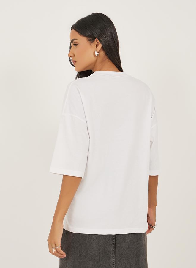 ستايلي تيشيرت واسع بطباعة شعار وأكتاف ساقطة - Image 4