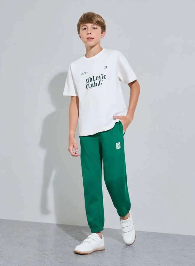 Styli Teen Boys Off White Graphic Print T-Shirt and Green Joggers Set