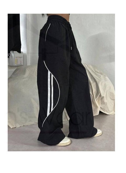 Wide black trousers with a unique medium waist, featuring a front tie and distinctive white side stripes, made from Summer Melton fabric by Nona Fashion.