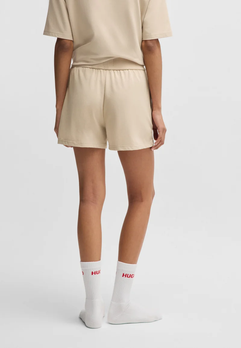 هوجو شورت بقصة مريحة من جيرسي مطاطي بشعار مطبوع