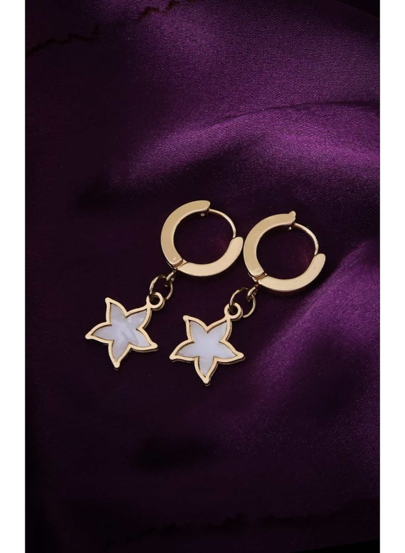 Luxuria Gold-tone hoop earrings with a dangling star coated in white enamel. - Image 1