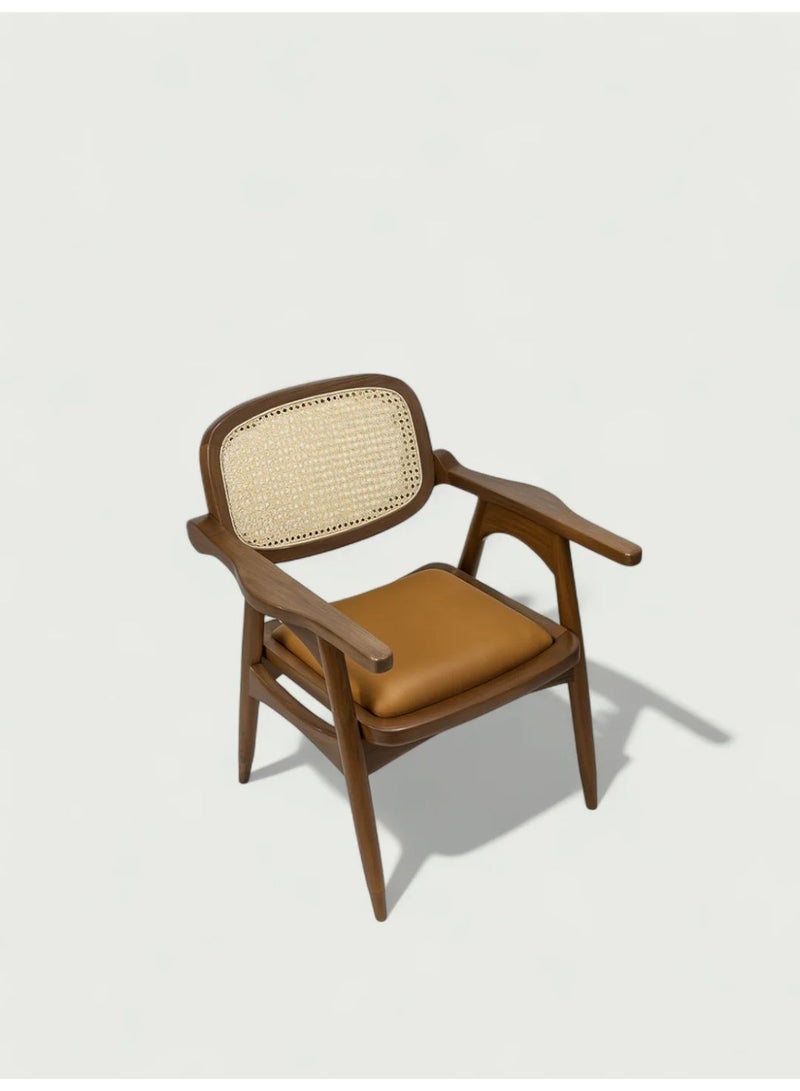 Goodwood كرسي بذراعين مصنوع يدويًا من خشب المانجو الصلب مع مسند ظهر من القصب الطبيعي ومقعد من الجلد الصناعي المبطن – تصميم فاخر مستوحى من منتصف القرن – مثالي لغرفة الطعام أو المكتب أو غرفة الجلوس – هيكل متين وتشطيب أنيق يوفر راحة وأناقة عالية - Image 1