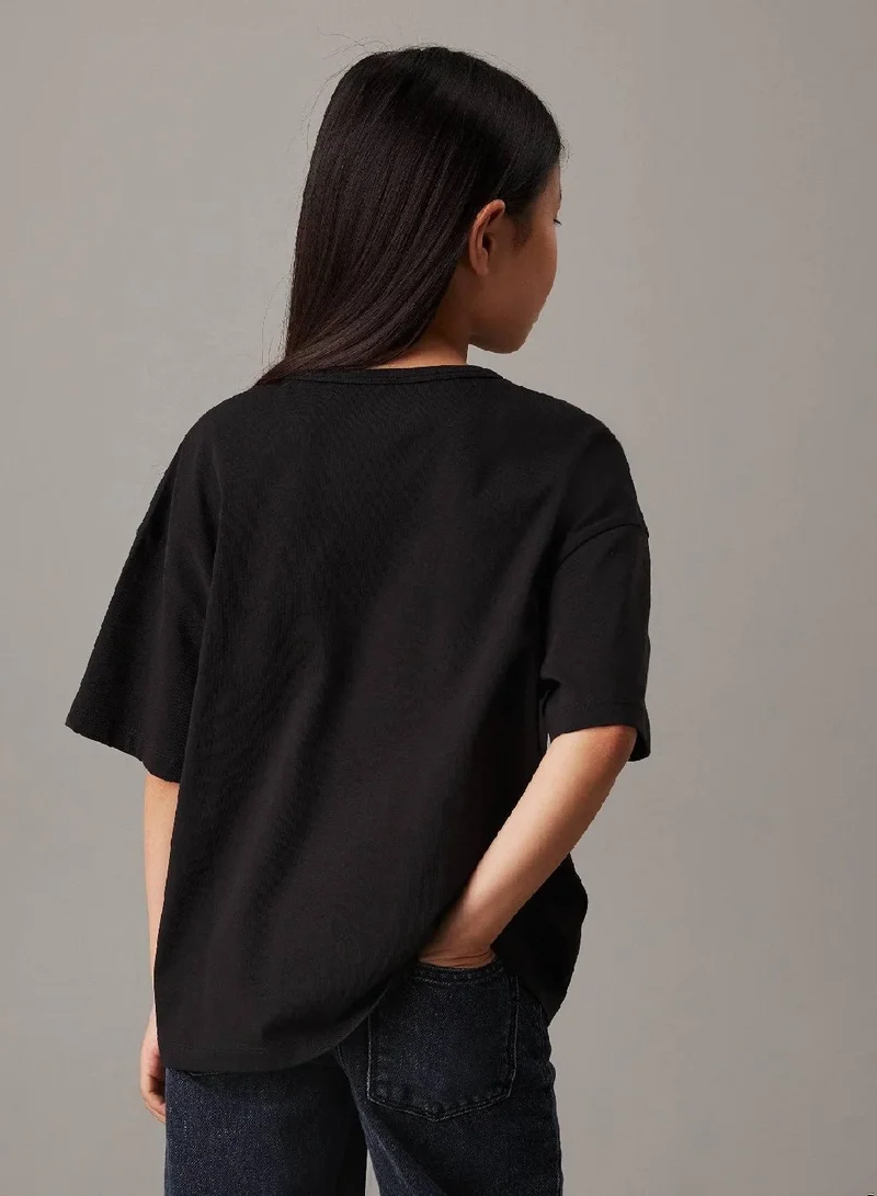 كالفن كلاين جينز تيشرت واسع مزين بشعار كلفن كلاين