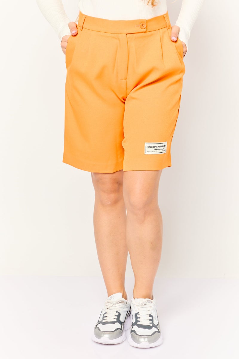 The Giving Movement شورتات نسائية بتصميم مخصص بشعار العلامة التجارية، برتقالي - Image 1