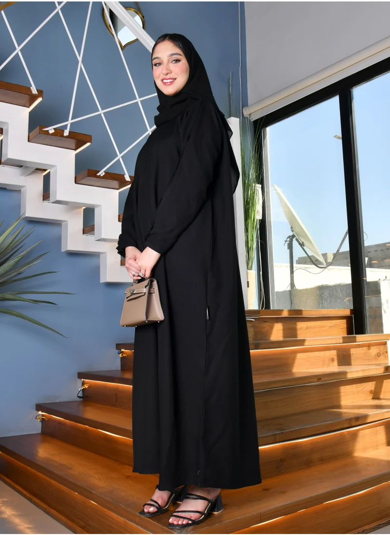 HAWRAA ABAYA Black abaya with a zipper closure and a high collar with narrow sleeves decorated with buttons