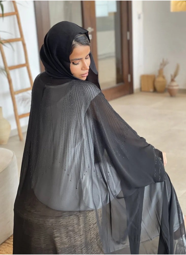 Bisht wrap abaya made of light fabric and decorated with lobes on the front and back in a soft way, adding elegance and elegance, with a plain black veil.