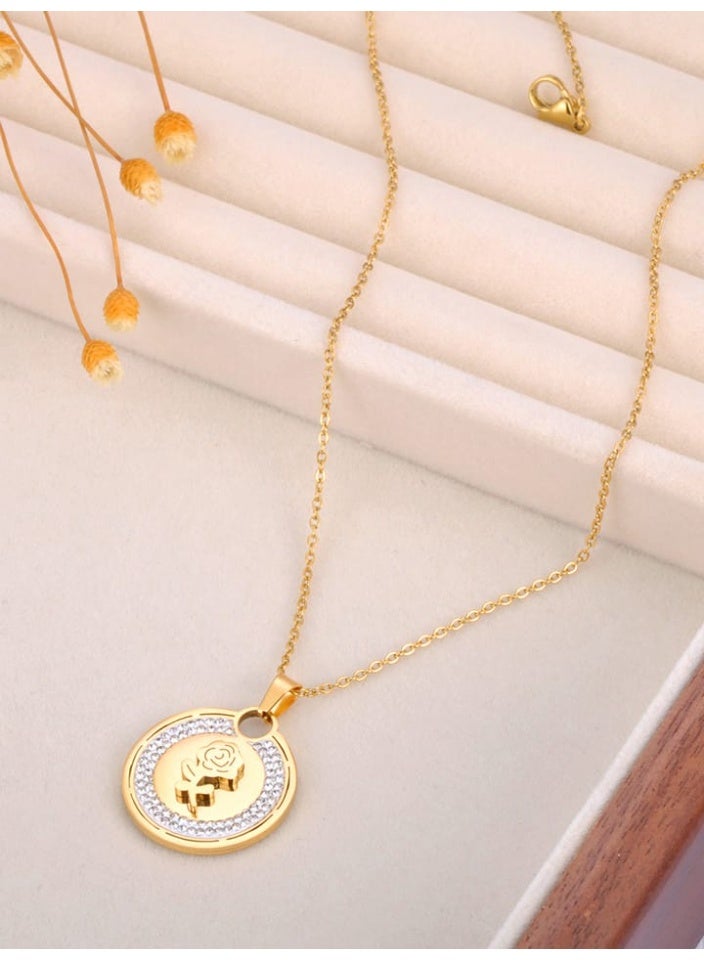 Luxuria A gold-colored, circular pendant featuring a prominent rose decoration in the center and surrounded by small crystals (rhinestones) on the outer edge of the circle. - Image 1