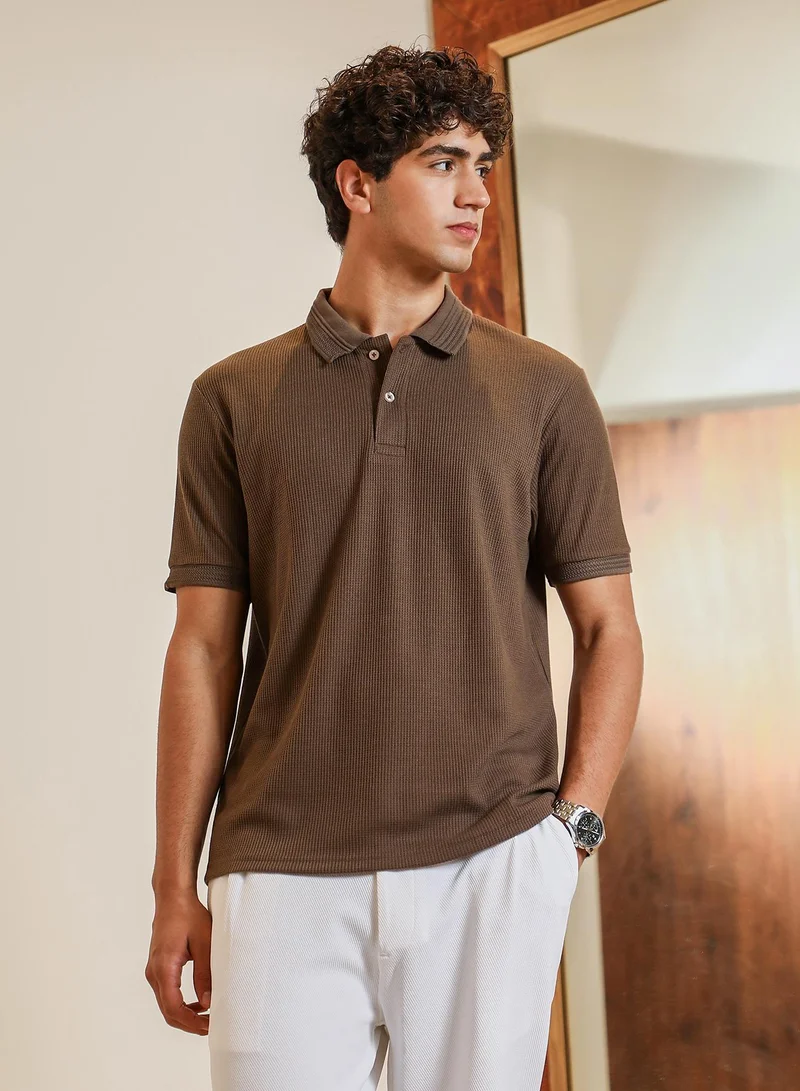 كامبوس سوترا تيشيرت بولو رجالي من كامبس سوترا بنسيج جاكار مضلع بياقة عريضة وأكمام قصيرة مكبلة وإغلاق بنصف أزرار بلون بني شوكولاتة