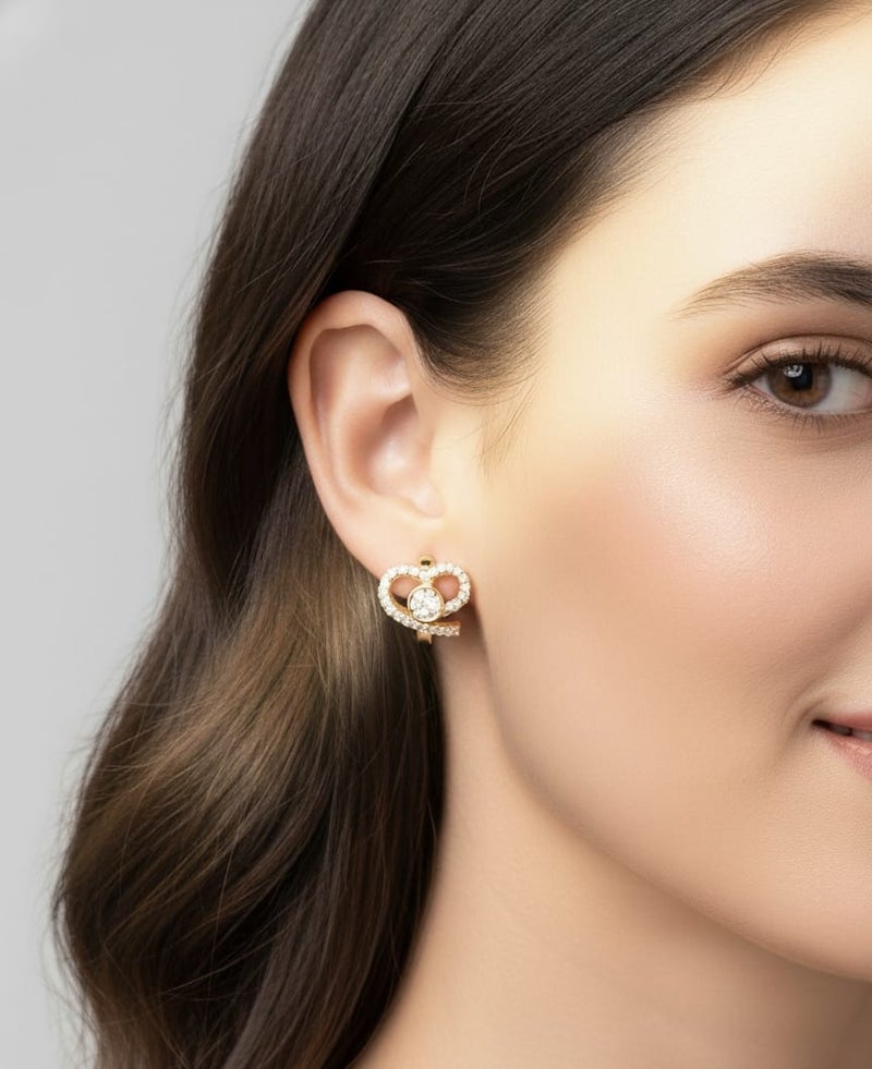 A delicate gold-plated hoop featuring a twisted heart design studded with dazzling white zircon stones. A shiny circular shape in the center adds an elegant touch. - Image 2