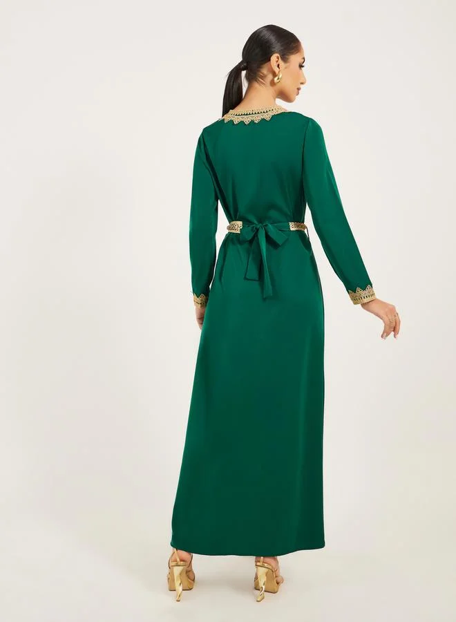 Styli Arabic Kaftan with V neck and gold lace trims at neckline, sleeve hem and centre front along with fabric belt. Lace trim on fabric belt