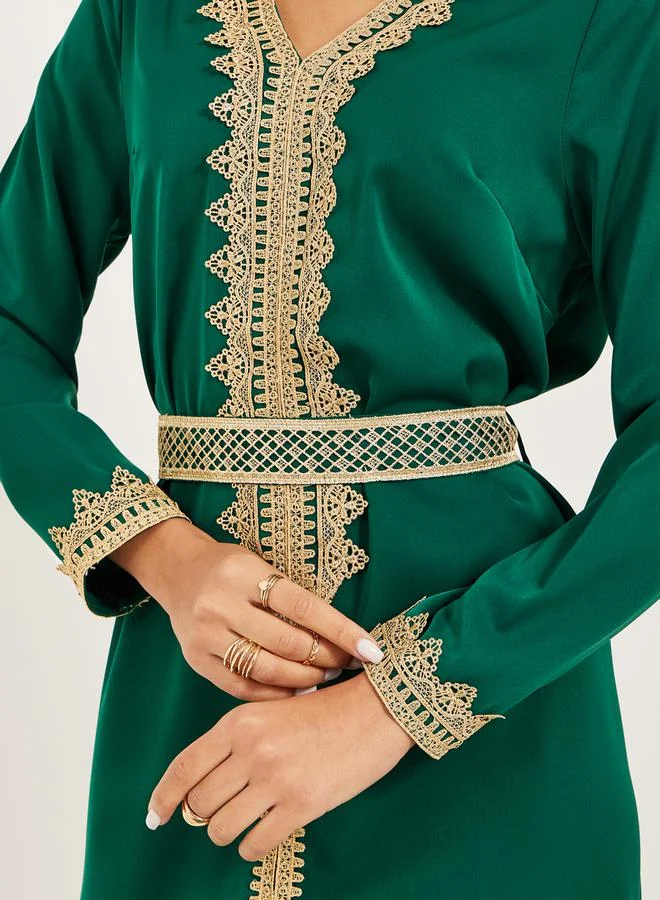 Styli Arabic Kaftan with V neck and gold lace trims at neckline, sleeve hem and centre front along with fabric belt. Lace trim on fabric belt