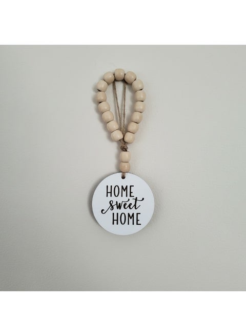 A trendy decorative hook with a unique circular design in the shape of a house, featuring the phrase "Home Sweet Home," measuring 10 cm in diameter. Made of premium Spanish MDF wood in white and 8 mm thick, it will add beauty and elegance to any corner of your home.