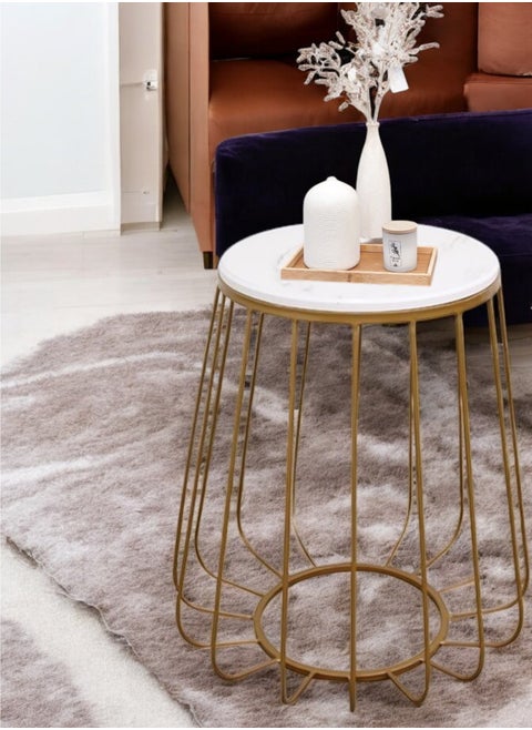 A stunning serving table with an elegant round design and a shiny gold finish, made of wood with a luxurious marble look. The table comes with perfect dimensions: 40 cm wide, 40 cm long and 60 cm high, making it an ideal choice for use as a coffee and tea table. In addition, this unique table is ideal for displaying artwork, decorations and books, adding a touch of luxury to any space.