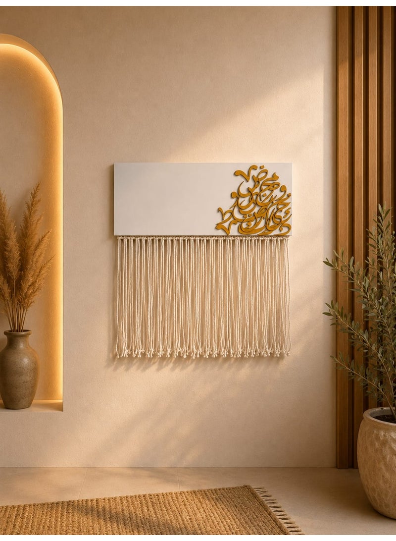 A modern wooden wall art piece featuring Arabic lettering and macramé cords.