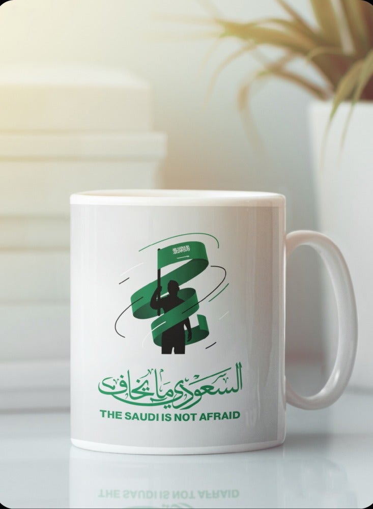 حكاية شمعة مج من السيراميك بطبعة تصميم "السعودي ما يخاف" بلون أبيض - Image 1