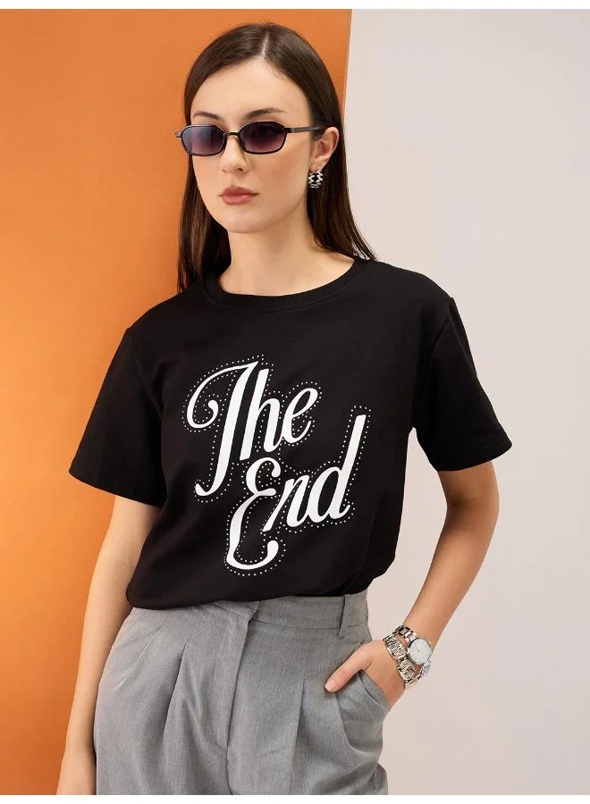 جلو باص تيشيرت قصير نسائي بياقة دائرية وأكمام قصيرة بطبعة كتابية وتفاصيل مزينة