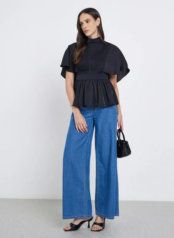 ستايلي بلوزة بياقة عالية وتفاصيل كسرات