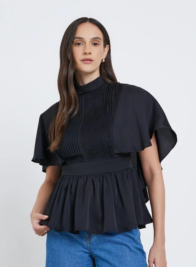 ستايلي بلوزة بياقة عالية وتفاصيل كسرات