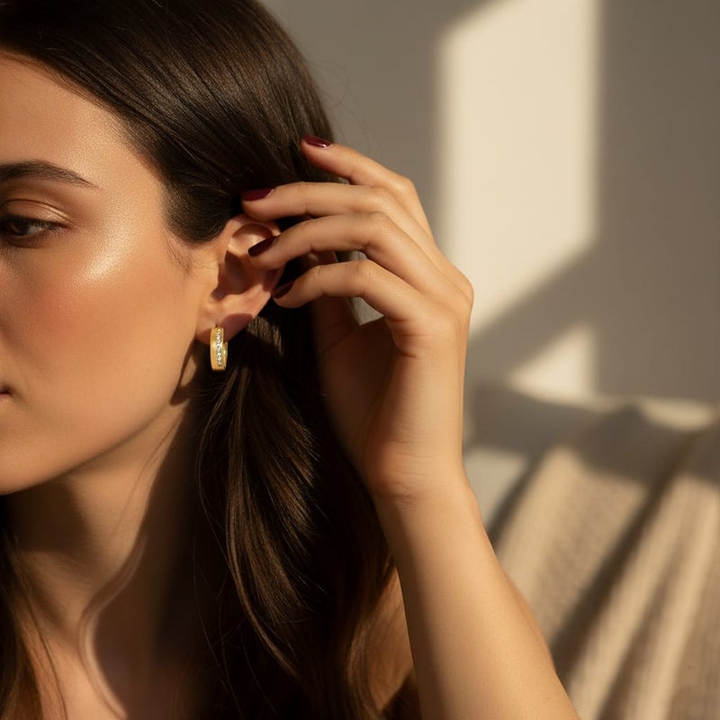 حلق رقيق مطلي باللون الذهبي ، بتصميم زهرة أنيقة. مرصع بـ حجر أحمر مركزي، تحيط به فصوص لامعة. يتميز بـ دلاية متدلية على شكل كرة ذهبية ناعمة. - Image 4