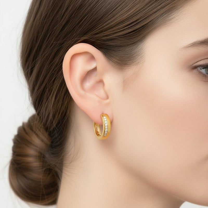 حلق رقيق مطلي باللون الذهبي ، بتصميم زهرة أنيقة. مرصع بـ حجر أحمر مركزي، تحيط به فصوص لامعة. يتميز بـ دلاية متدلية على شكل كرة ذهبية ناعمة. - Image 2