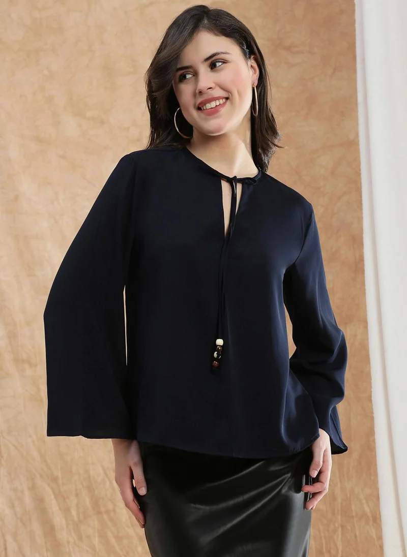 جلو باص بلوزة نسائية بلون أزرق بياقة على شكل حرف  وأكمام واسعة من قماش الجورجيت