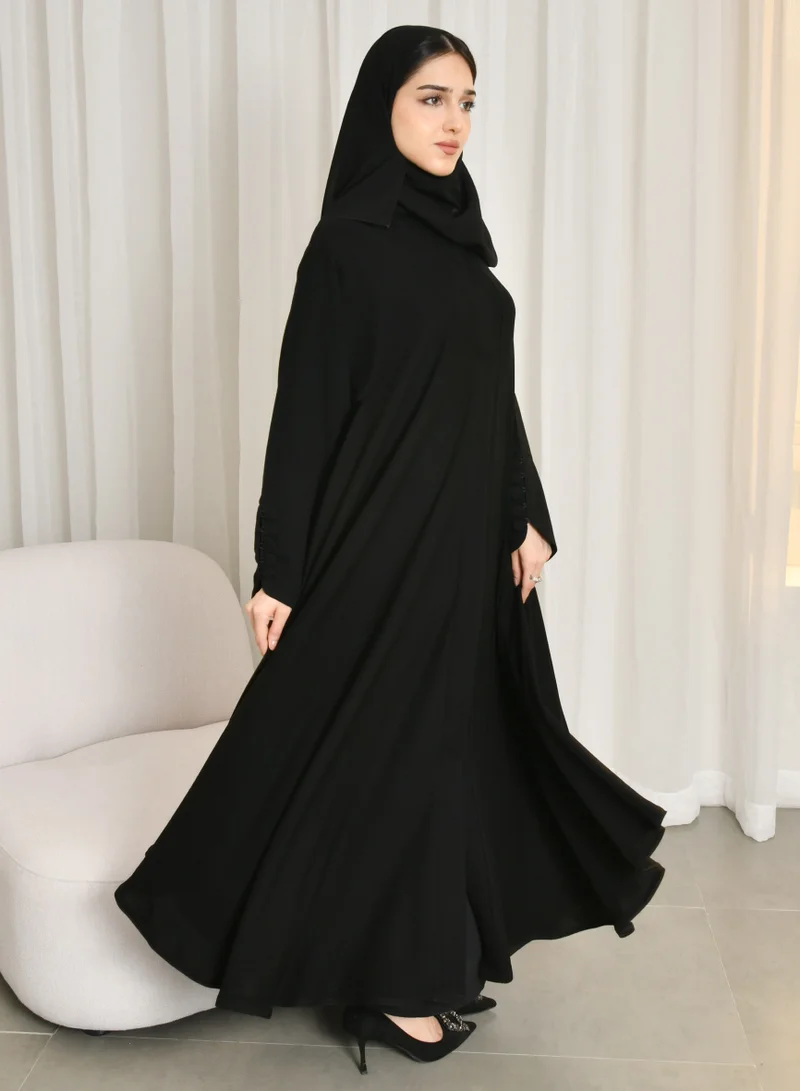 HAWRAA ABAYA Black quarter-cloche abaya with snaps and sleeves decorated with button closures