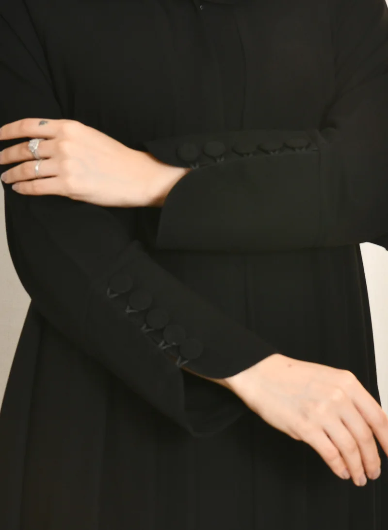 HAWRAA ABAYA Black quarter-cloche abaya with snaps and sleeves decorated with button closures