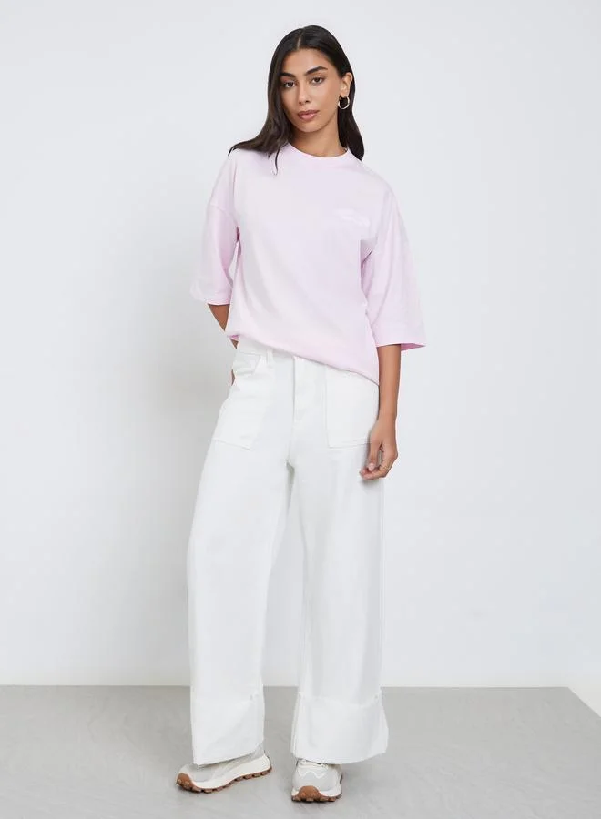 ستايلي تيشيرت واسع مُطرّز بتفاصيل مشطوفة