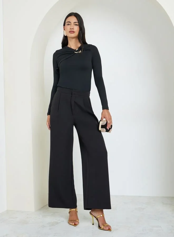 ستايلي بلوزة محبوكة بتفاصيل معدنية ذهبية