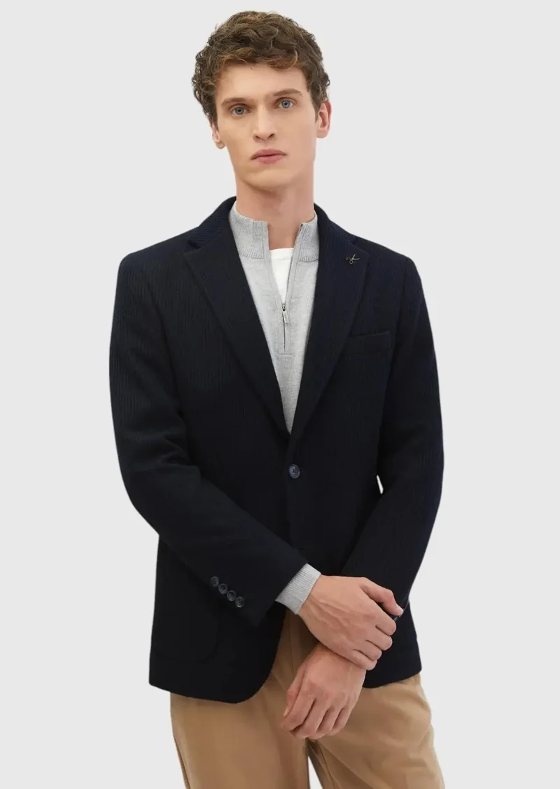 رامسي قميص أزرق داكن بنقوش، بقصة ضيقة عند الكتفين، وجاكيت من مزيج الصوف